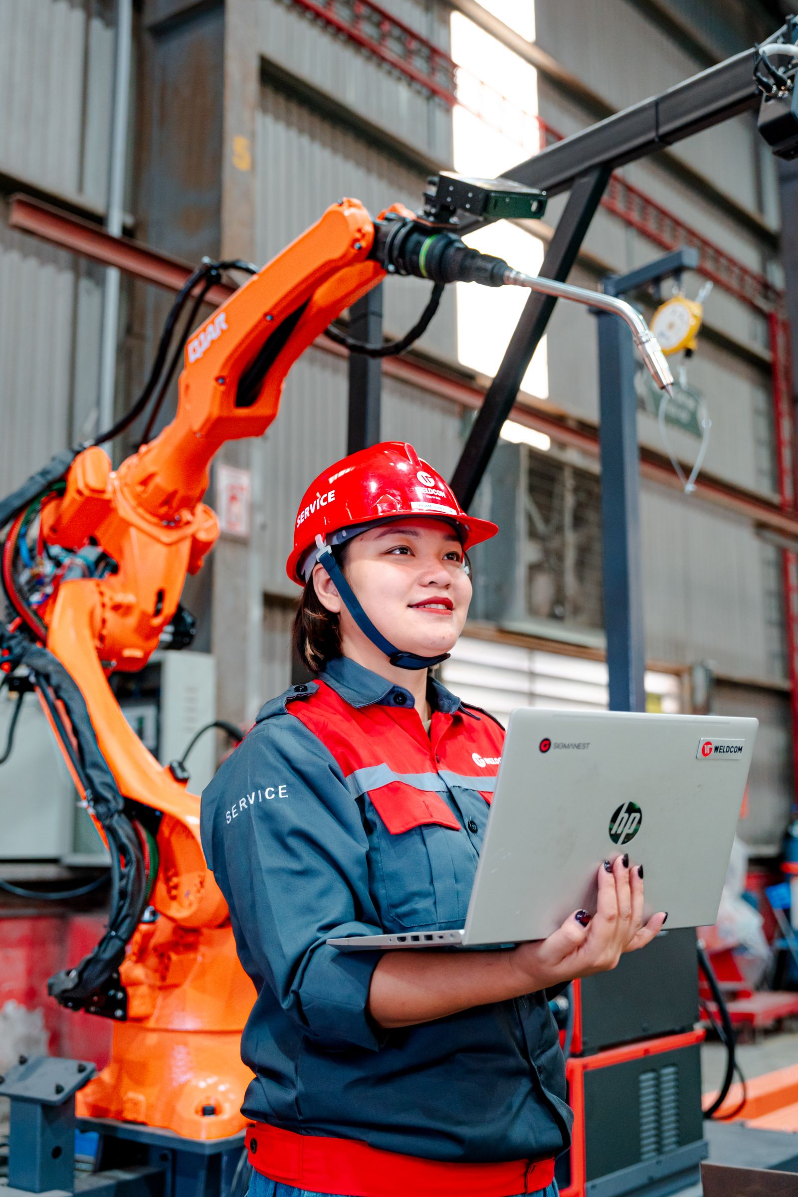 Engineer working beside an industrial robot in a factory